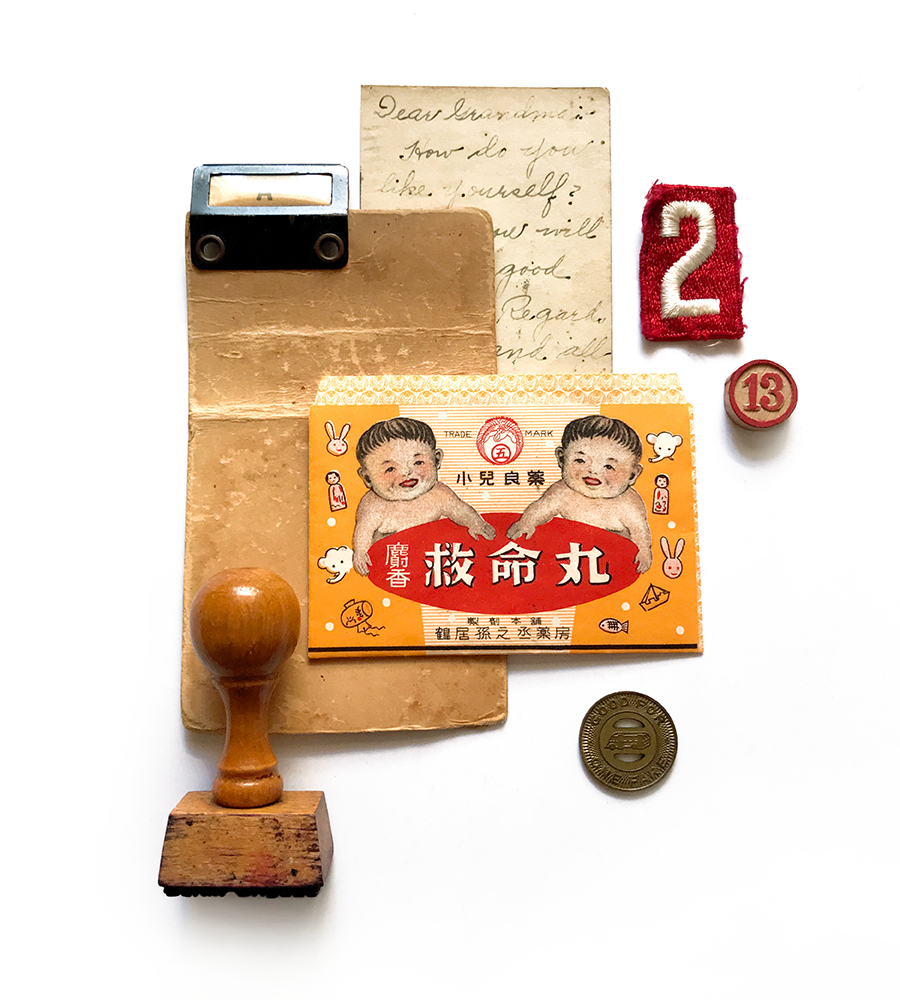 photograph of found item collage of vintage objects like a vintage card, scout badge, stamp and japanese medicine envelope