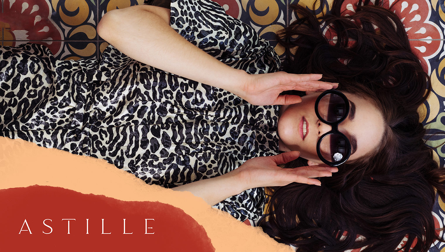 Astille model in animal print boiler suite with supporting graphics and brand logo