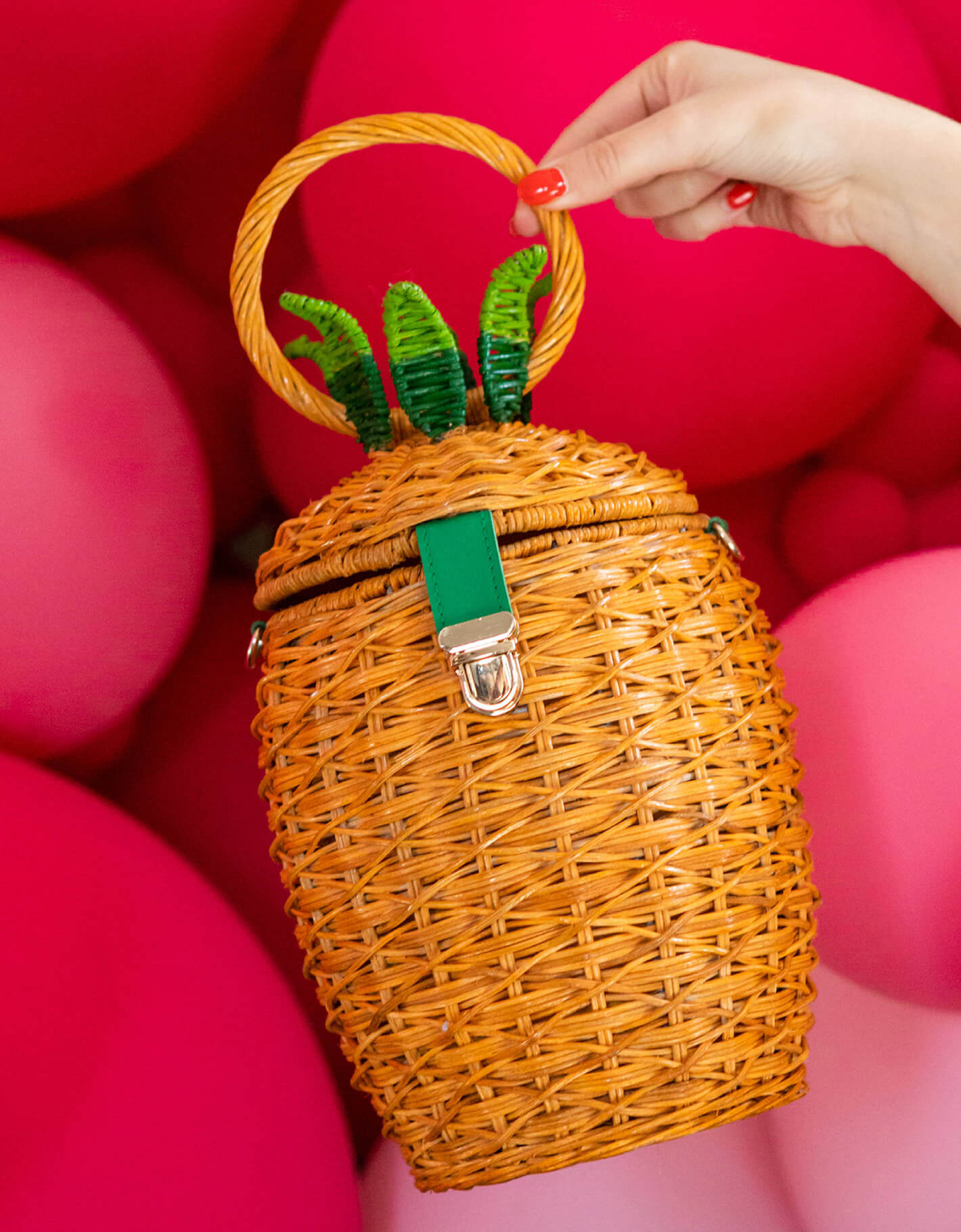 Image of pinapple-shaped wicker handbag with red balloons in the background