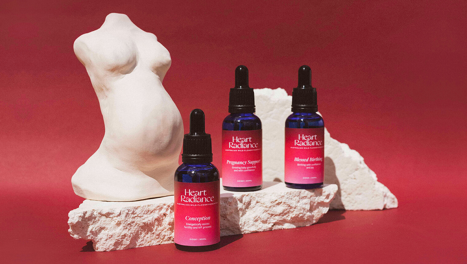 Thumbnail for the brand identity case study of HeartRadience. The image shows the pink-labelled dropper bottles on white stones in front of a pink background.