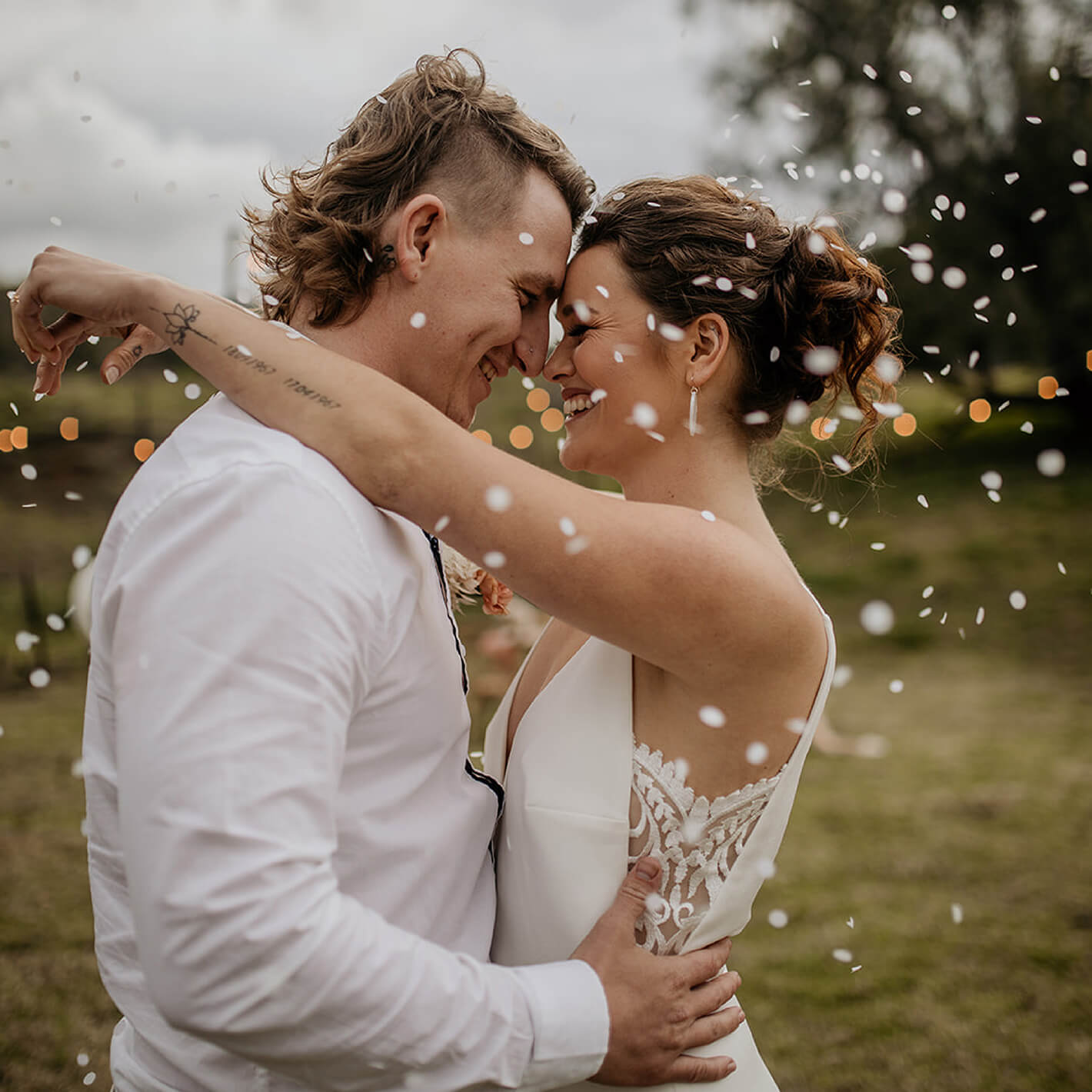 Rebranding case study image featuring brand photography for Eco Confetti. A country-styled couple stare into each other’s eyes, gold and white metallic confetti surrounding them.