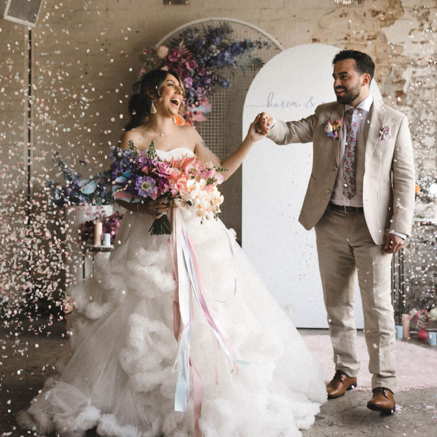 Rebranding case study image featuring brand photography for Eco Confetti. A contemporary-styled couple laugh at the altar, pastel paper confetti surrounding them.